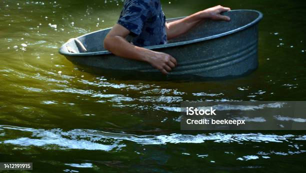 The Boys Sail On A Boat Made Of Old Tin Tubs A Bucket A Barrel A Bowl An Ovalshaped Flower Pot They Fall On The River With Their Hands They Are Childrens Adventures In The Village Stock Photo - Download Image Now