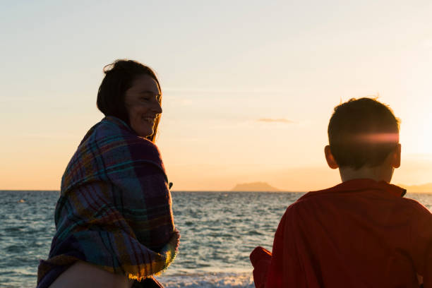 istock Mother and son talking on the beach at sunset 1412194537