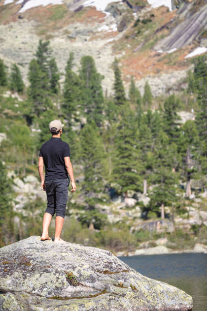 istock young hiker by a lake in mountains 1412195725