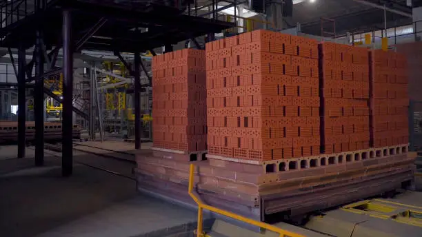 Plant for the production of bricks. Plant for production building material with ready brick, construction industrial. Production of bricks on plant. Workflow, close-up. Brick stacks. Many bricks HD