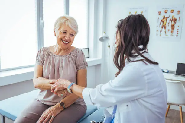 Photo of Hand of doctor reassuring her female patient.