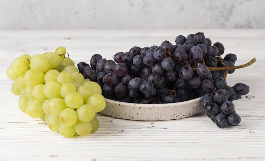 fresh juicy white and red grapes on plate