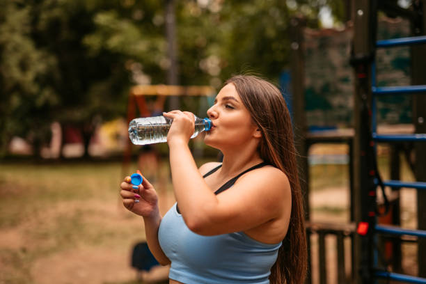 istock Young Woman Drinking Water After Exercising 1412202459