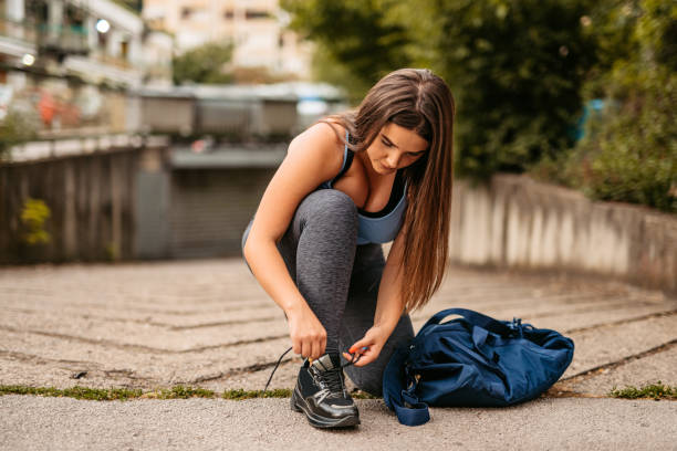 istock Young Woman Tying Up Her Shoelaces Before Jogging 1412203466