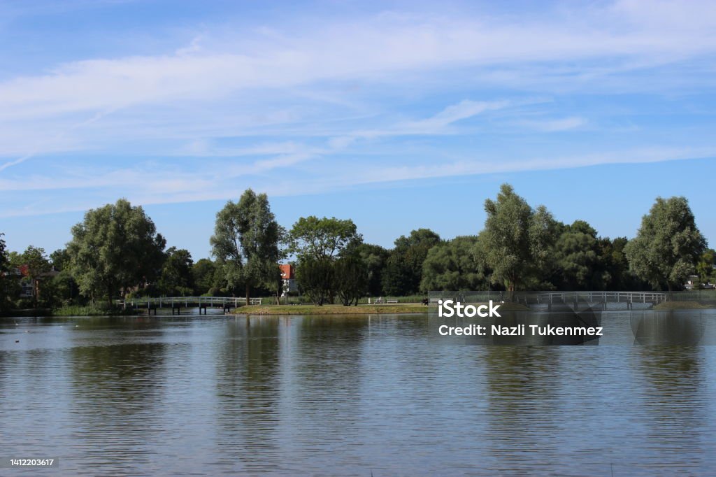 Beautiful Lake Landscape With Bridges In The City Park, Trees And Blue Sky The view of Lake Knieperteich with White Bridge in Stralsund  (Mecklenburg-Vorpommern). You can cycle around the lake and take a walk. Backgrounds Stock Photo