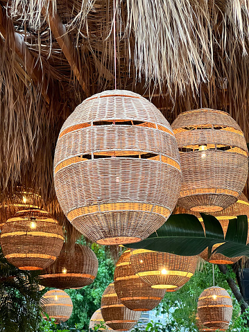 View of Rattan Woven Pendants and Straw Canopy. Outdoor Cafe-Restaurant Lighting.