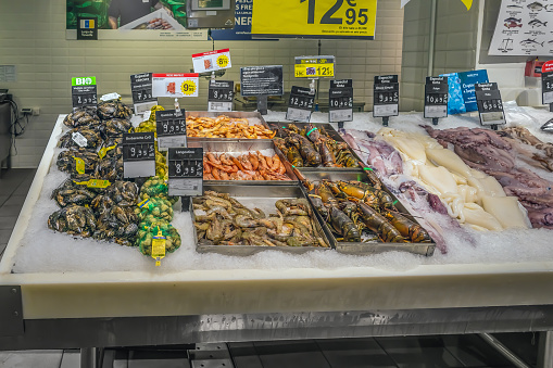 Santa Cruz de Tenerife, Spain - November 24, 2021: Seafood counter in a supermarket in the Meridiano shopping center in Santa Cruz. Different marine life lies in ice at the market with price tags