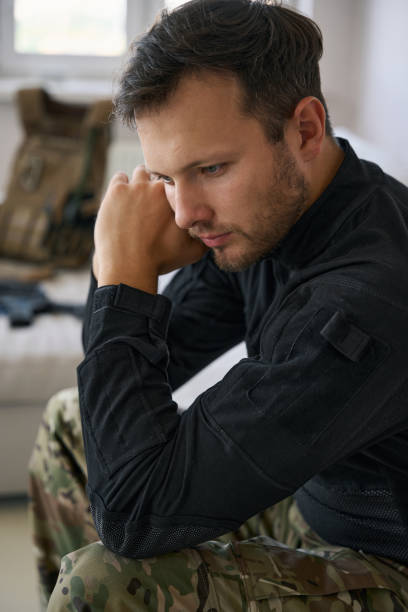 istock Upset military man sitting at home in thoughts 1412206420