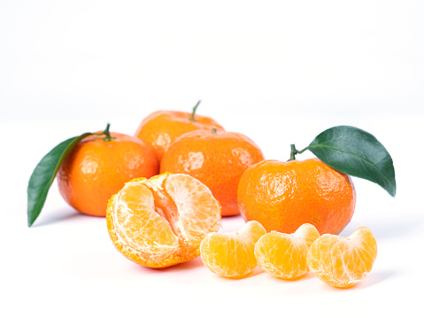 essential oils with orange fruit and mint leaves on white background
