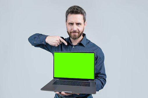 mature man showing green screen. modern wireless laptop. copy space. webinar pc advertisement. businessman presenting product. presentation on computer. office manager point finger on video conference