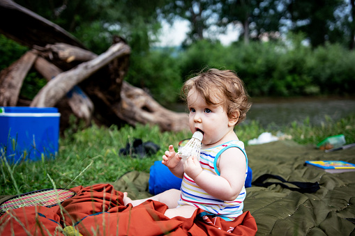 Baby girl enjoying day in nature on picnic