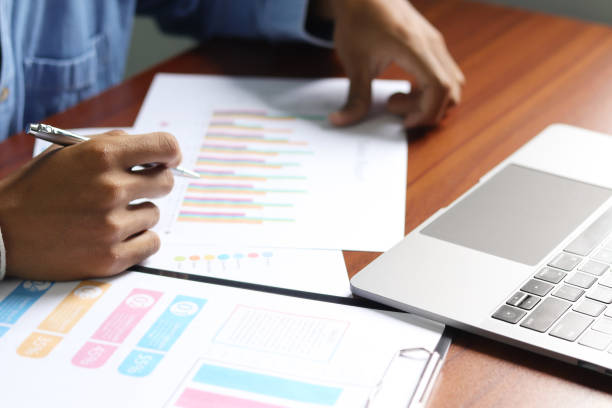 istock Businessman using laptop to analyze graphs and charts on his desk. Successful work planning 1412210749