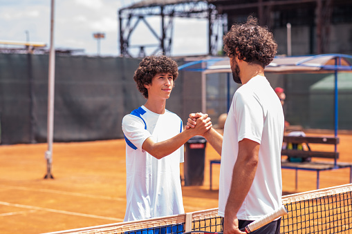 Portrait of handshake of two padel tennis players - Padel players embracing after win a padel match.