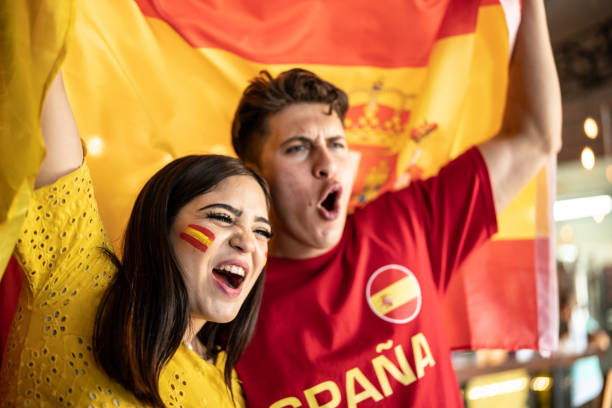 istock Couple watching a soccer game and celebrating with a spanish flag 1412211200