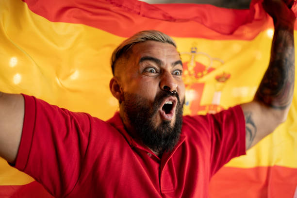 istock Mid adult hispanic man celebrating with spanish flag 1412211906