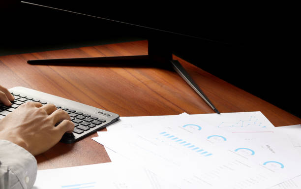 istock Businessman using laptop to analyze graphs and charts on his desk. Successful work planning 1412212276