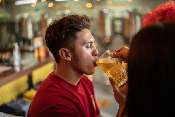 istock Young man drinking a beer at a bar 1412212300