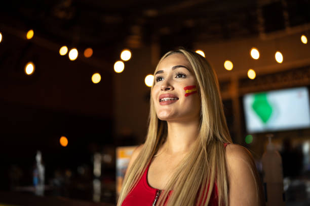 Young spanish woman watching a soccer game at a bar