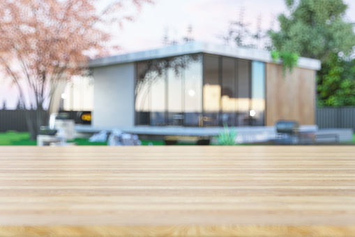 Empty Wooden Desk with a Blurred Villa House Background. 3D Render