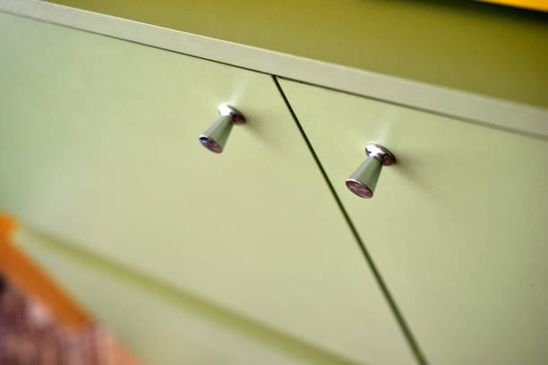 Green bedside table with silver handles indoors.Contemporary design.