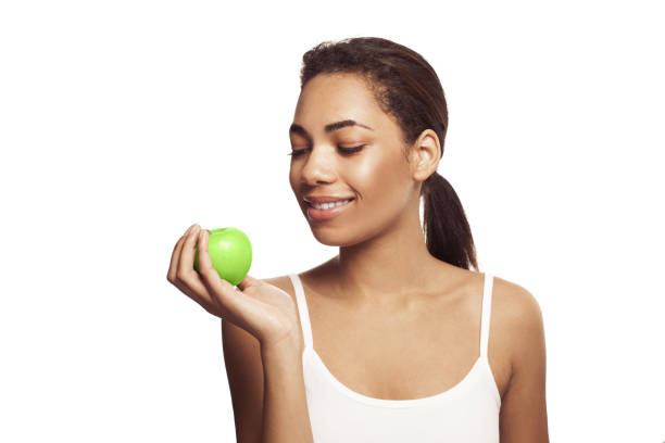 Cute young woman with beautiful smile holding green apple. Healthy lifestyle, nutrition, dieting, weight loss,  dental care and healthy teeth conÑept. Cute young woman with beautiful smile holding green apple. Healthy lifestyle, nutrition, dieting, weight loss,  dental care and healthy teeth conÑept. ept stock pictures, royalty-free photos & images