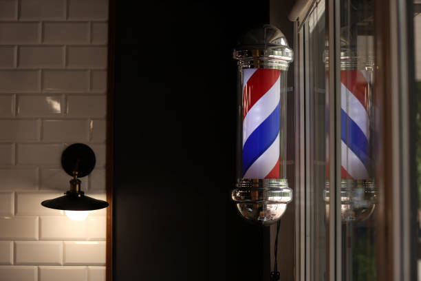 istock Barber pole spinning at night. International barbershop pole sign. A barber pole calling for people at street. Vintage barbershop. Salon. 1412214829