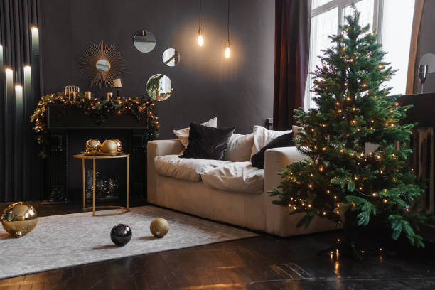 interior navideño con un hermoso árbol de navidad, sofá, bombillas y fondo oscuro. - home decorating living room luxury fireplace fotografías e imágenes de stock