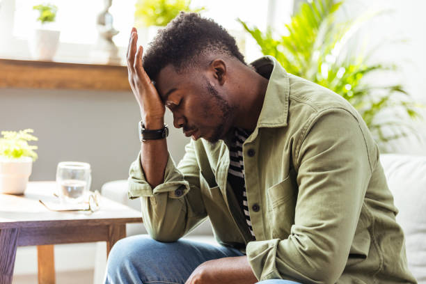 istock Frustrated middle aged man with hand on head sitting on couch at home. 1412215767