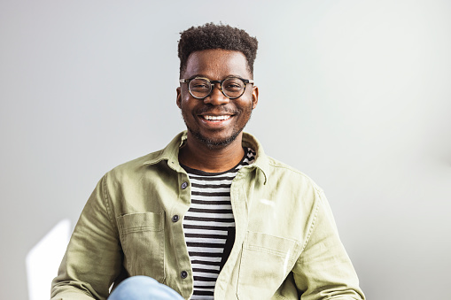 Shot of a handsome young man relaxing on the sofa. Portrait of a handsome young man. Studio shot of a confident young businessman posing against a gray background