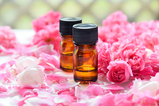 Essential oil jar for aromatherapy with rose flowers, rose quartz