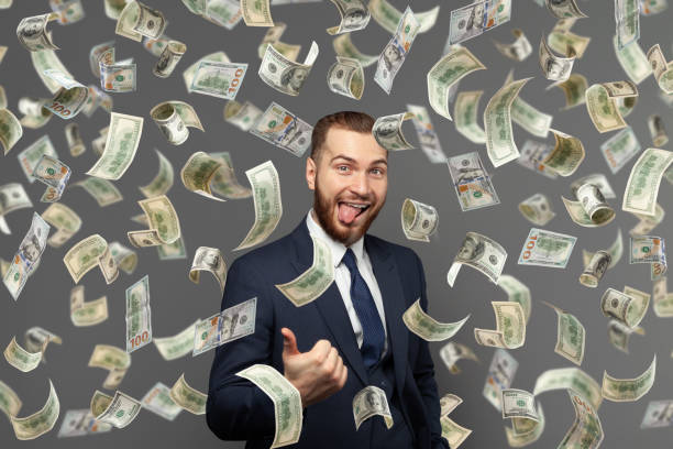 istock Funny excited businessman and flying dollar banknotes 1412217632
