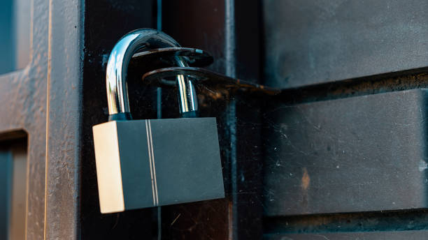 istock Padlock hangs on metal gate at rural house closeup 1412217968