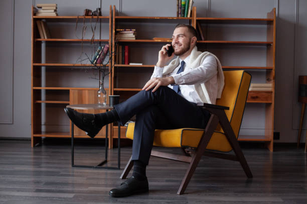 istock Happy smiling handsome man with the mobile phone indoor 1412218090