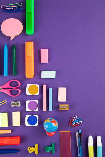 Directly above view of a large group of school supplies on purple background