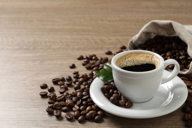 istock Cup of aromatic hot coffee and beans on wooden table. Space for text 1412220280