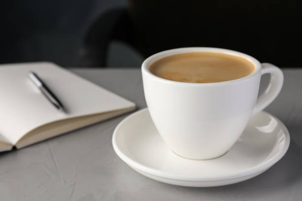 istock Cup of americano on light grey table in office, closeup. Coffee Break 1412221148