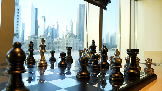 Black and gold chess close up with city landscape with skyscraper background. Business strategic formation in the chess game with city background.