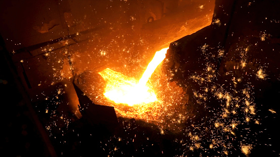 Pouring of liquid metal in open hearth workshop of the metallurgical plant. Smelting of the metal in the foundry at steel mill.