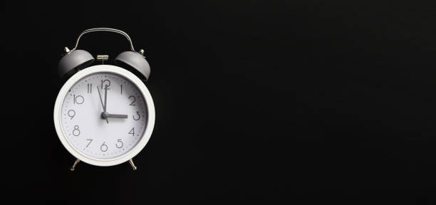istock White alarm clock in dark background with copy space. Time concept. 1412221858
