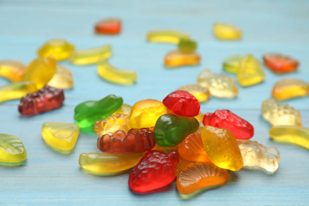 istock Delicious gummy fruit shaped candies on light blue wooden table, closeup 1412223537
