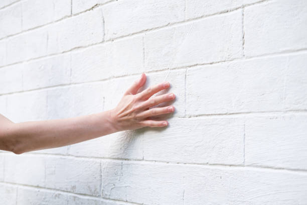 Woman's hand on the background of a white brick wall