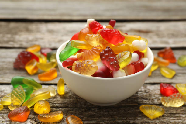 istock Delicious gummy fruit shaped candies on wooden table, closeup 1412224709