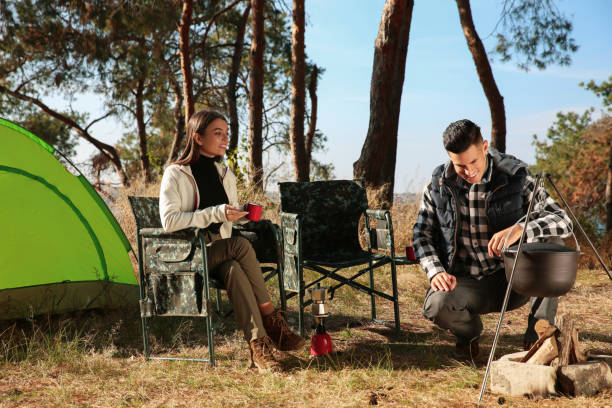 istock Couple resting near bonfire at camping site 1412224875