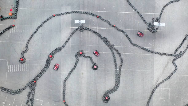 vista aérea da pista de kart com pequenos karts vermelhos em movimento, corrida e conceito de automobilismo. mídia. visão superior das curvas na pista de kart. - go cart - fotografias e filmes do acervo