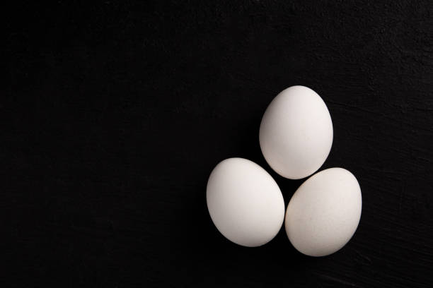 istock Chicken white eggs on a black background. Farm products. Natural eggs. Chicken eggs on the table 1412225304