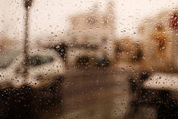 fondo lluvioso de la ciudad. gotas de lluvia en el vidrio de la ventana el día de otoño. ventana de casa mojada con gotas de lluvia. foto de alta calidad - usa antique car blue fotografías e imágenes de stock