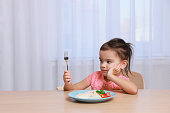 istock Cute little girl refusing to eat her breakfast at home, space for text 1412225701