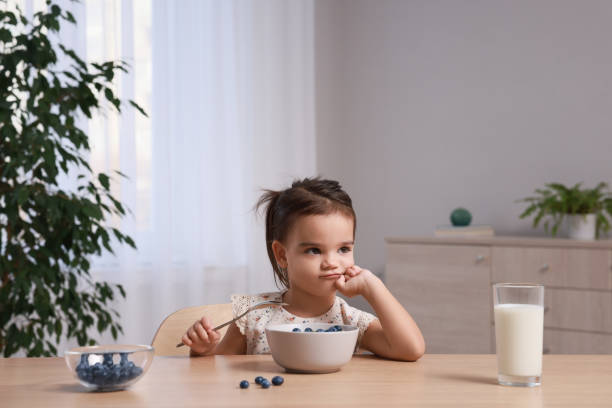 istock Cute little girl refusing to eat her breakfast at home 1412225799