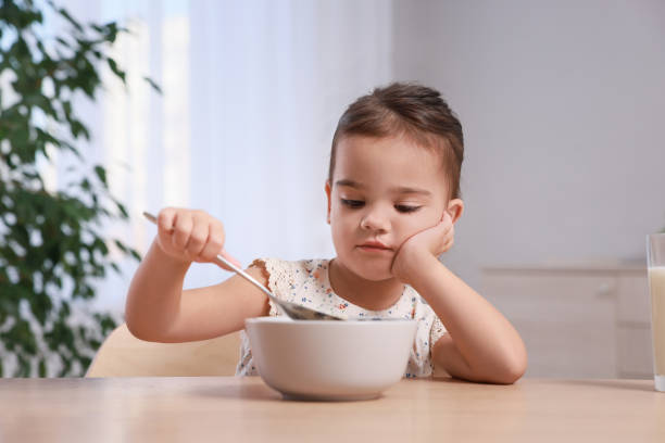 istock Cute little girl refusing to eat her breakfast at home 1412225845