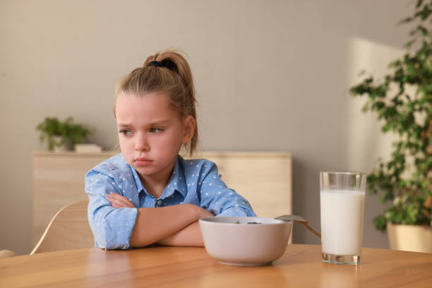 istock Cute little girl refusing to eat her breakfast at home 1412225912